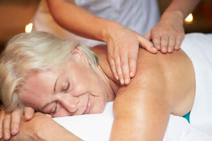 Older woman receiving massage to her back