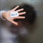 person blurred behind wavy glass pressing help sign up to the glass