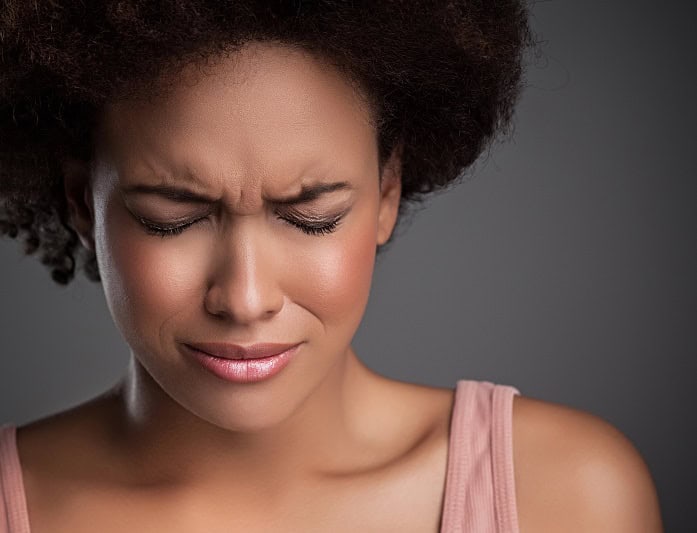 Woman clenching eyes closed in pain