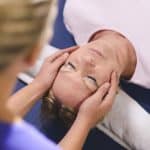 Reiki Master performing reiki therapy to woman