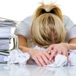 Woman with head down on her desk suffering from massage burnout