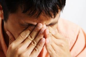 Stressed man holding his head in his hands