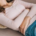 woman clutching stomach in pain