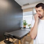 Man standing in massage therapy office nervously awaiting a massage