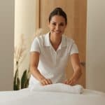 Professional massage therapist preparing massage office for client