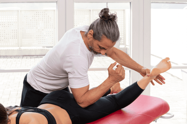 Male massage therapist working on massage client for treatment of sciatic pain