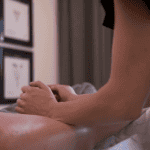 Massage therapist using the forearms to massage client's leg